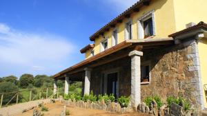 una casa de piedra con una valla de piedra delante de ella en B&B Sa Soliana, en Telti