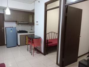 cocina con mesa y nevera azul en Apartemen Bogor Valley Family Staycation, en Bogor