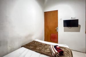 サマリンダにあるGood Sleep Near Samarinda Central Plaza RedPartnerのベッドとテレビのある小さな部屋