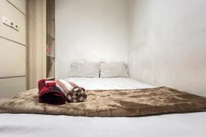 サマリンダにあるGood Sleep Near Samarinda Central Plaza RedPartnerの赤いバックパックが付いたベッドルームのベッド1台