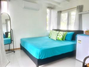 拉罗汤加Sharnytas Studio AIR CONDITIONED的窗户客房内的一张蓝色的床