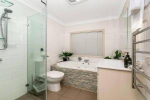 a bathroom with a tub and a toilet and a shower at Tranquility with Spa & Jetty in Woy Woy +15 photos