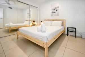 Un dormitorio con una cama grande y un espejo. en Saffire Seaside Serenity, en Mooloolaba 20 fotos más