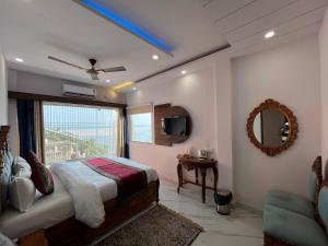 a bedroom with a bed and a large window at Hotel Shannti Inn with Ganges View in Varanasi