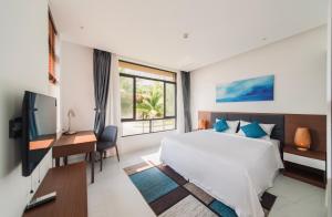 a bedroom with a bed and a desk and a television at Hese Pool Villas & Resort Cam Ranh in Cam Ranh