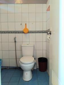 Un baño con un inodoro blanco en una cabina. en TheLavanderDream of Terbaik Apartments, en Puerto Princesa City