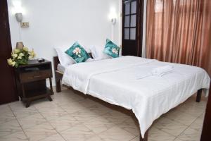 a bedroom with a white bed and a night stand at AESTHETICS - THE HOME STAY in Shillong