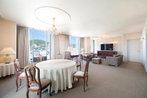 a room with a table and chairs and a living room at Hotel New Nagasaki in Nagasaki