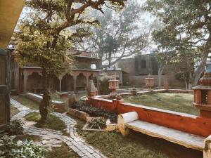 a house with a garden with a tree and a building at Vrinda Kunja Ashram in Vrindāvan