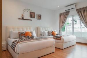 um quarto com duas camas e um sofá em Georgetown Karpal Singh Getaway 4BR 娱乐设施洋房乔治市 em Jelutong mais 37 fotografias