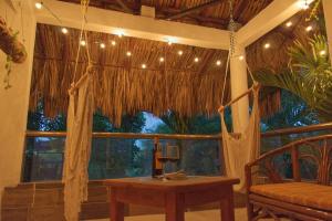 a room with a hammock and a table and a window at Gran Ubicación Terraza Privada Jacuzzi in Cozumel