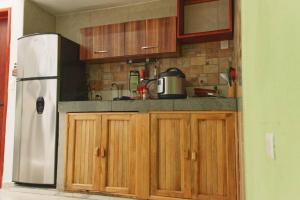 a kitchen with wooden cabinets and a refrigerator at Gran Ubicación Terraza Privada Jacuzzi in Cozumel