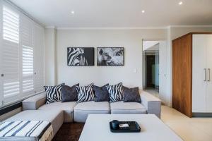 a living room with a couch and a table at Masingita Towers - Luxurious Apartment Condo in Sandton in Johannesburg +39 photos