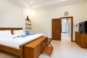 パタヤ・サウスにあるVilla Franken Luxury Pool Villaの大きなベッドとテレビのある寝室