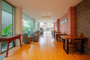a restaurant with tables and chairs and a brick wall at The Wings Boutique Hotels Krabi Ko Lanta in Ko Lanta