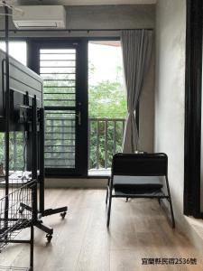 una stanza con una sedia davanti a una finestra di hsueh_house a Città di Yilan