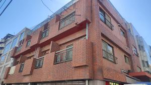 un edificio de ladrillo rojo en una calle de la ciudad en High-end Tokyo shinjuku Central Park Flat 5, en Tokio