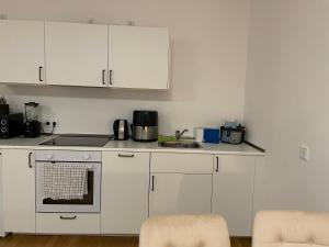 a kitchen with white cabinets and a stove top oven at Precious Airport Stay in Schönefeld