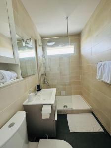 a bathroom with a sink and a toilet and a mirror at Appartement résidence calme proche centre-ville in Caen +23 photos