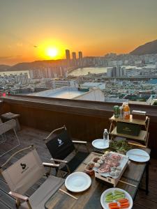 a table with food on top of a balcony with the sunset at 영도 여는 in Busan