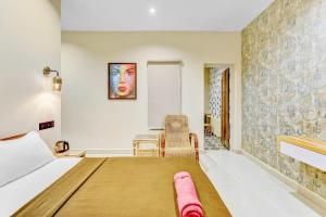 a hotel room with a bed and a chair at IZI Beach Stay Mahabalipuram in Chennai