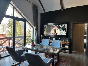 a living room with a glass table and blue chairs at Casa Larisa Antonia Apartments in Sinaia