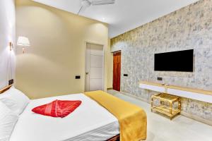 a bedroom with a bed and a tv on a wall at IZI Beach Stay Mahabalipuram in Chennai +16 photos