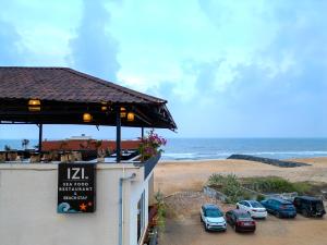 a group of cars parked in a parking lot next to the beach at IZI Beach Stay Mahabalipuram in Chennai