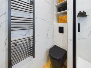 baño con aseo negro y paredes de mármol en Loft neuf derrière la Cathédrale, en Estrasburgo 17 fotos más