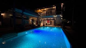 a swimming pool in front of a house at night at Laman Padi Villa in langkawi in Ulu Melaka
