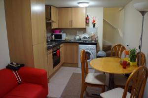 a small kitchen with a table and a red chair at Lower Cathedral Road Apartment in Cardiff