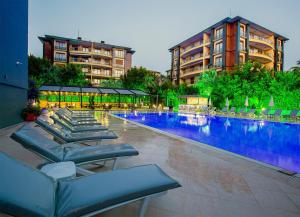 a large swimming pool with lounge chairs in front of a building at Grand Alisa Hotel (Ex. Royalisa Hotel) in Alanya