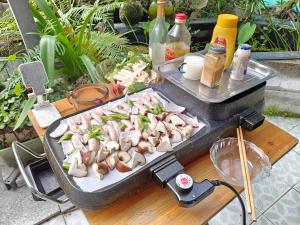 成都koko's garden and cats --4mins walk from jingjusi metro st ation, English-speaking service的餐桌上的烤肉和蘑菇烧烤
