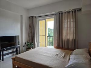 碧瑶Studio Unit near Mines View Park, Baguio City的一间带床和大窗户的卧室
