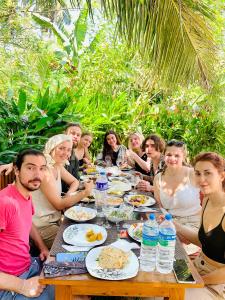a group of people sitting around a table eating food at Chill House Udawalawa in Udawalawe
