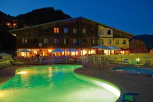 Una piscina frente a un edificio por la noche. en VTF Le Rafour, en Arêches 42 fotos más