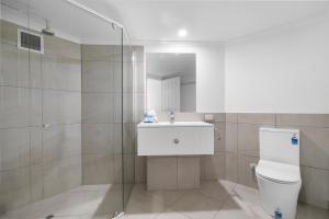 a bathroom with a toilet and a sink and a shower at Serenity Apartments Noosa in Noosa Heads
