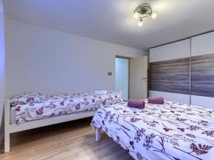 a bedroom with two beds and a wall with at Paola in Kršan