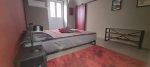 a bedroom with a bed with a red rug and a window at Castellazzo 1 in Ivrea