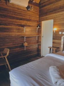 une chambre avec un lit et un mur en bois dans l'établissement Purnama Home, à Toyapakeh