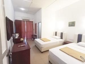 a hotel room with two beds and a desk at Collection O Analisa Beach Resort in Pangkor +62 photos