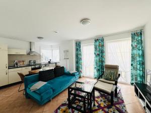 a living room with a blue couch and a table at Ferienwohnungen Birkenhof in Bad Wörishofen