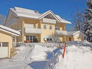 a house with a pile of snow in front of it at Am Badezentrum Ferienwohnungen in Ruhpolding