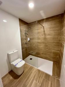 une salle de bain avec toilettes et douche dans l'établissement Jardines Suites GP, à Cordoue
