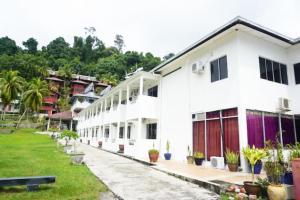 a row of white buildings with potted plants at Collection O Analisa Beach Resort in Pangkor