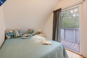 a bedroom with a bed and a large window at Ferienhaus am Peenestrom in Quilitz