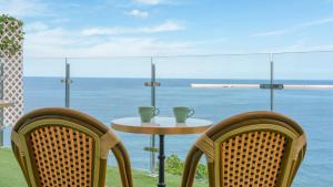 a table and two chairs with a view of the ocean at Samcheok Peacehousing Spa Pet Pension in Samcheok +4 photos