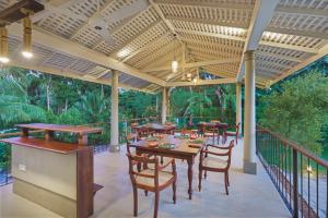 a patio with tables and chairs on a deck at Kurundu Walawwa Villas and Suites by The Clarks in Ahungalla