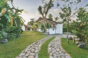 a house with a garden and a walkway at Kurundu Walawwa Villas and Suites by The Clarks in Ahungalla