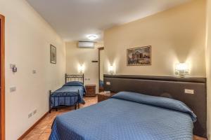 two beds in a hotel room with blue sheets at Locanda San Cosimato in Rome